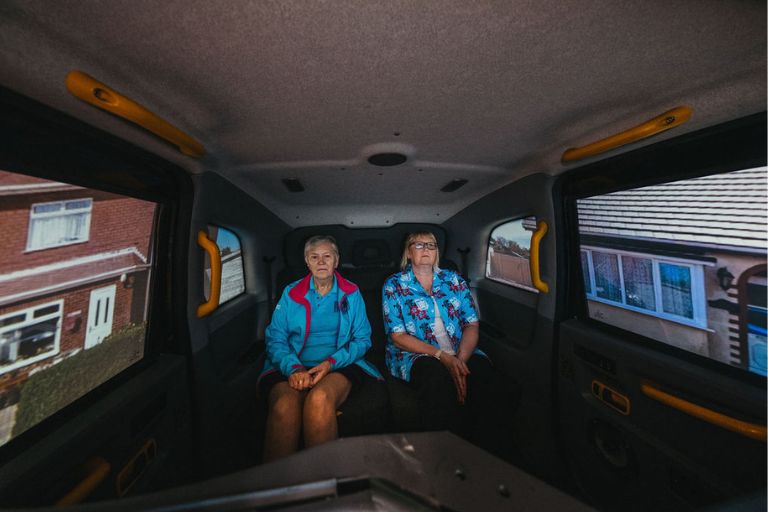 Audience members watch Driving Home from the back of a black cab